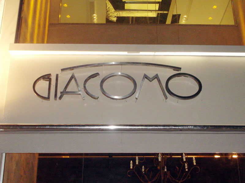 Logo em letras caixa de aço escovado.